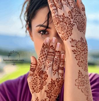 Bridal henna artist in Muscat, Oman applying detailed Arabic mehndi on hands